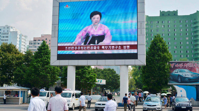 Pessoas passam em frente a um telão que transmite o anúncio do governo da Coreia do Norte de mais um teste nuclear