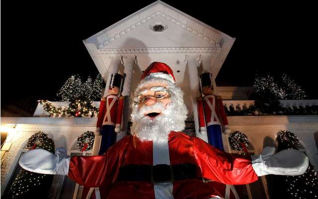 A large Santa Claus sits at the entrance of a decorated house at the Dyker Heights Christmas Lights in the Dyker Heights neighborhood of Brooklyn, New York City, U.S., December 23, 2016. REUTERS/Andrew Kelly - RTX2WCOR