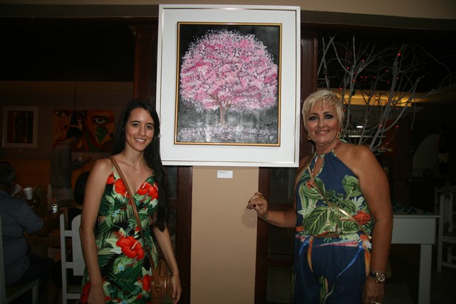 Maira Queiroz ao lado da tela de sua autoria e da avó Tina Berg