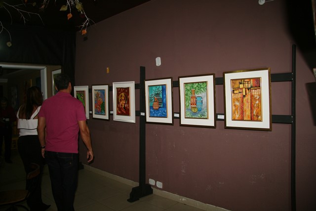 Visitantes conferem as obras de Tina Berg. Ao todo, a artista expôs 69 telas.