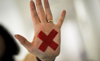 O sinal “X” feito com batom vermelho (ou qualquer outro material) na palma da mão ou em um pedaço de papel, o que for mais fácil, permite que a pessoa treinada reconheça que aquela mulher foi vítima de violência doméstica e, assim, acione a Polícia Militar.