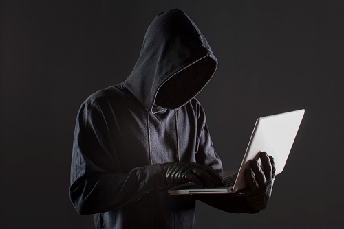 vista-lateral-do-hacker-masculino-com-luvas-e-laptop