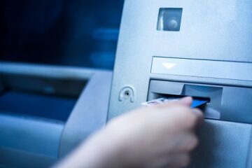 Woman using cash machine-ATM,close up view.