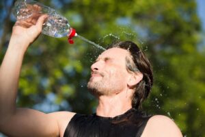 corredor-de-fitness-bebendo-e-espirrando-agua-em-seu-rosto-imagem-engracada-de-belo-macho-refrescante-durante-o-treino_549566-606